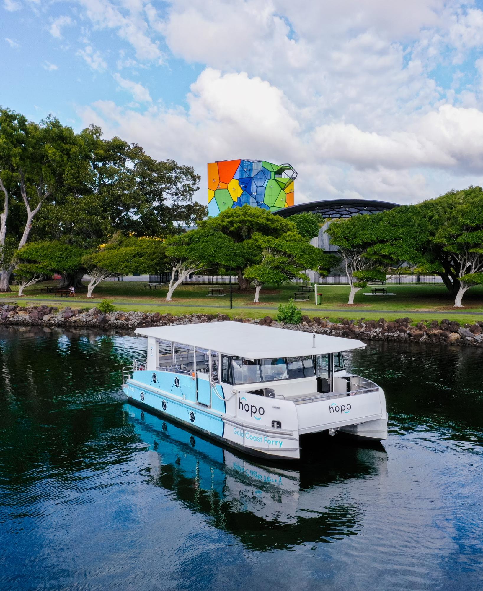 Blue and white Hopo Ferry in front of HOTA, Home of the Arts